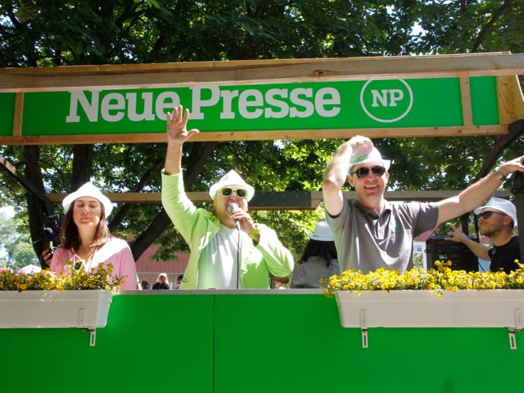 Menschen auf einem Festwagen.